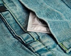 Eine Jeans in Großformat, in deren Tasche ein Kondompäckchen steckt.