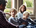 Eine vierköpfige Familie sitzt auf einem Sofa.