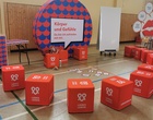 Mehrere rote Würfel liegen am Boden einer Turnhalle mit der Aufschrift Liebesleben.