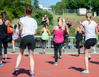 Eine Gruppe von Frauen macht unter Anleitung eines Trainers Sport im Freien