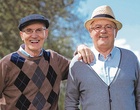 Zwei lachende ältere Männer schauen in die Kamera.