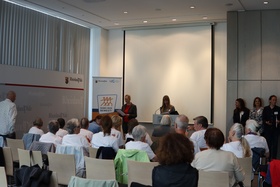 Ein Auditorium hört einer Referentin zu.