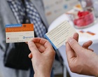 Zwei Hände halten je einen Organspendeausweis, einmal sieht man die Vorderseite, einmal die Rückseite.