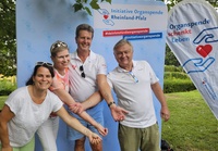 Vier Personen vor einem Banner der Initiative Organspende