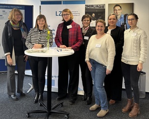 Mehrere Frauen stehen um einen Stehtisch herum.