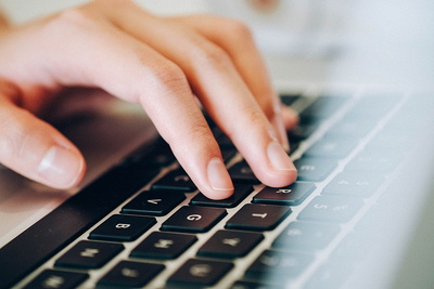 Finger tippen auf einer schwarzen Computertastatur