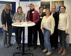 Mehrere Frauen stehen um einen Stehtisch herum.